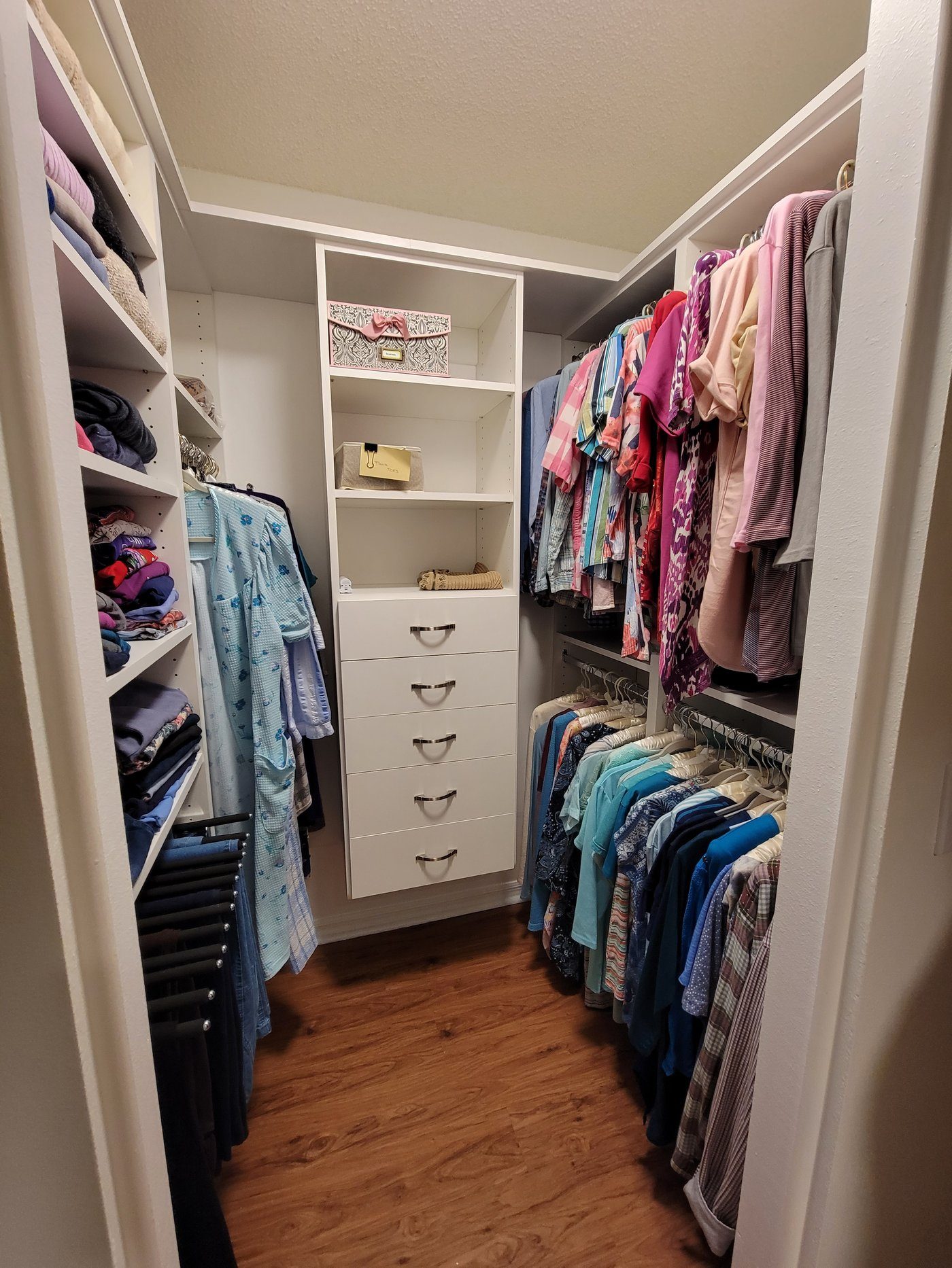 Closet with colorful folded clothing by Create More Space