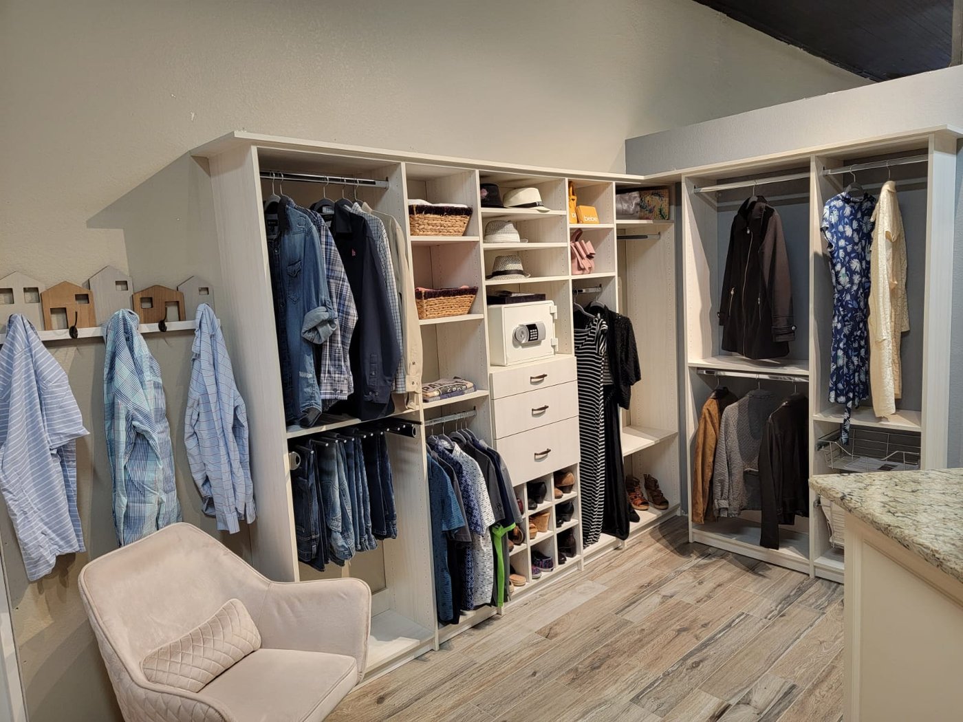 Walk-in closet with hanging jackets and seating by Create More Space