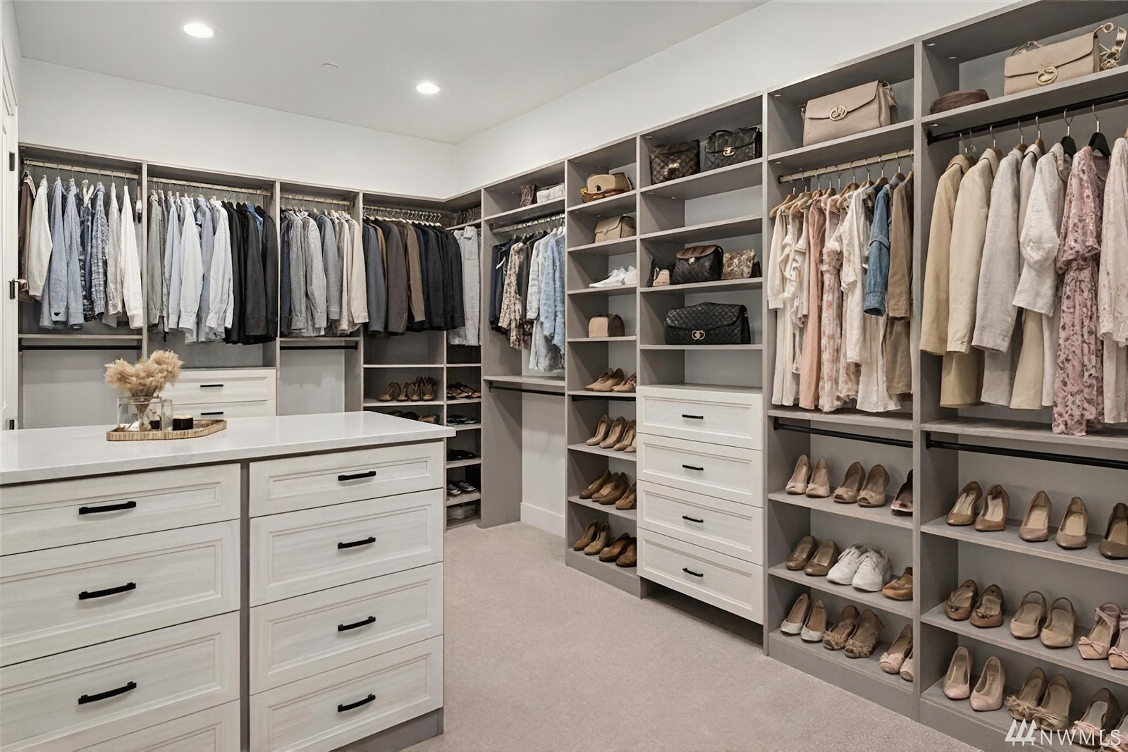 Large custom walk-in closet with center island and organized shelving by Create More Space