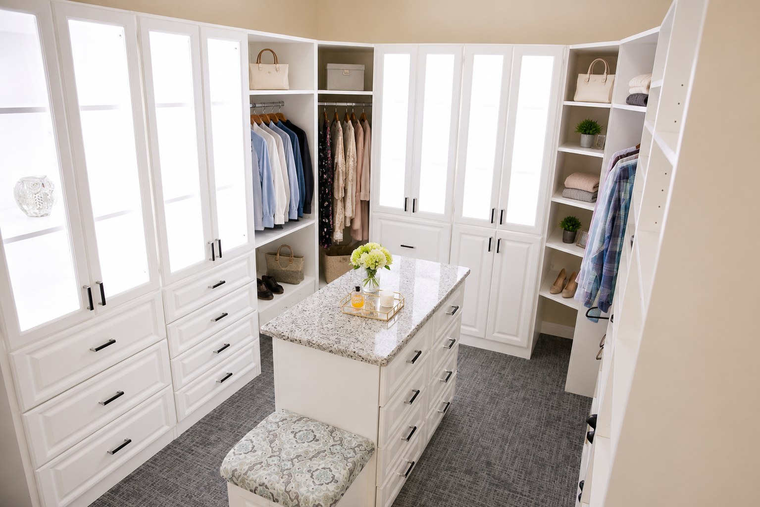 Walk-in closet with marble-top island and bench seating by Create More Space
