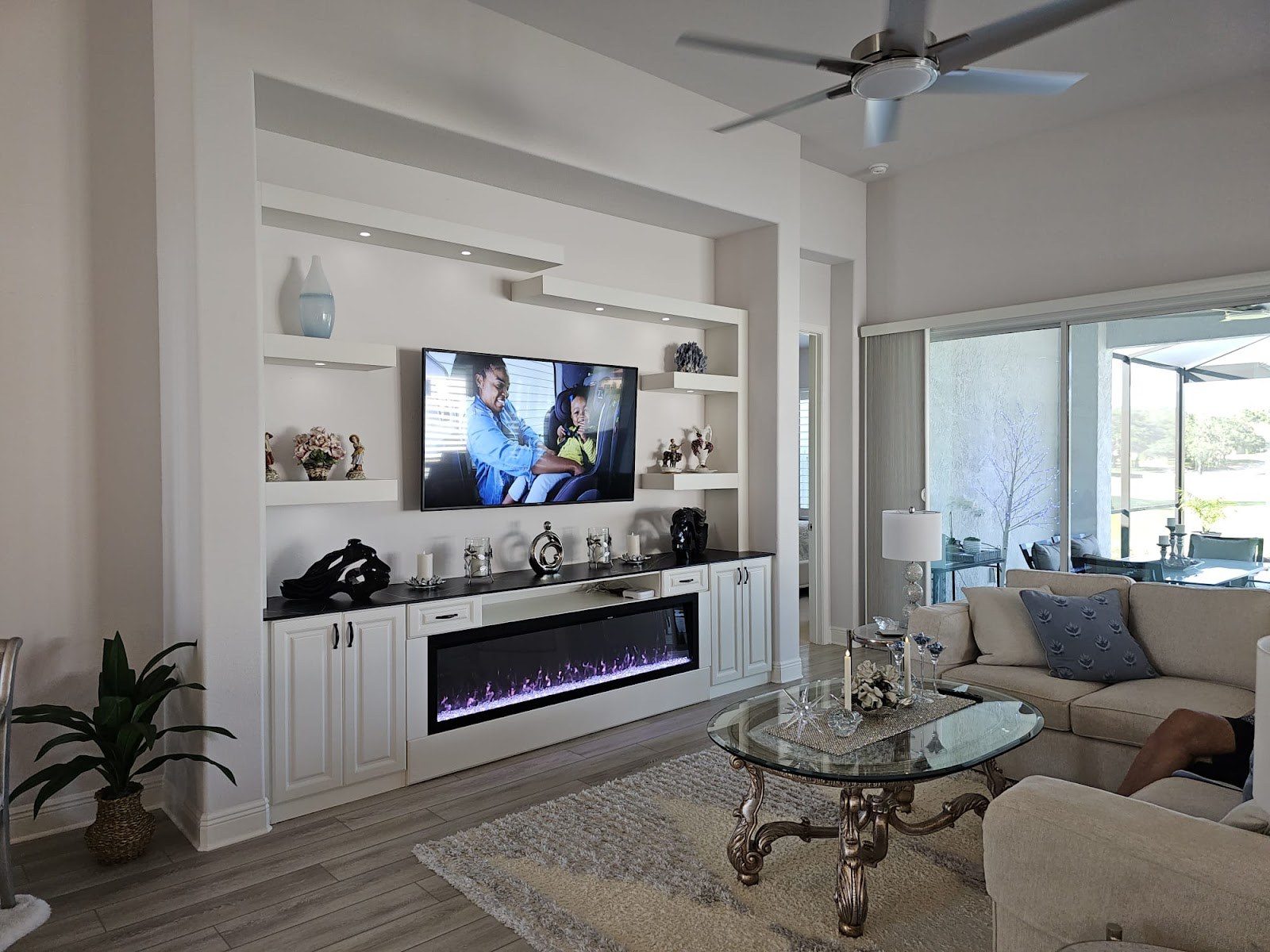 Living room entertainment center with fireplace and open shelving by Create More Space