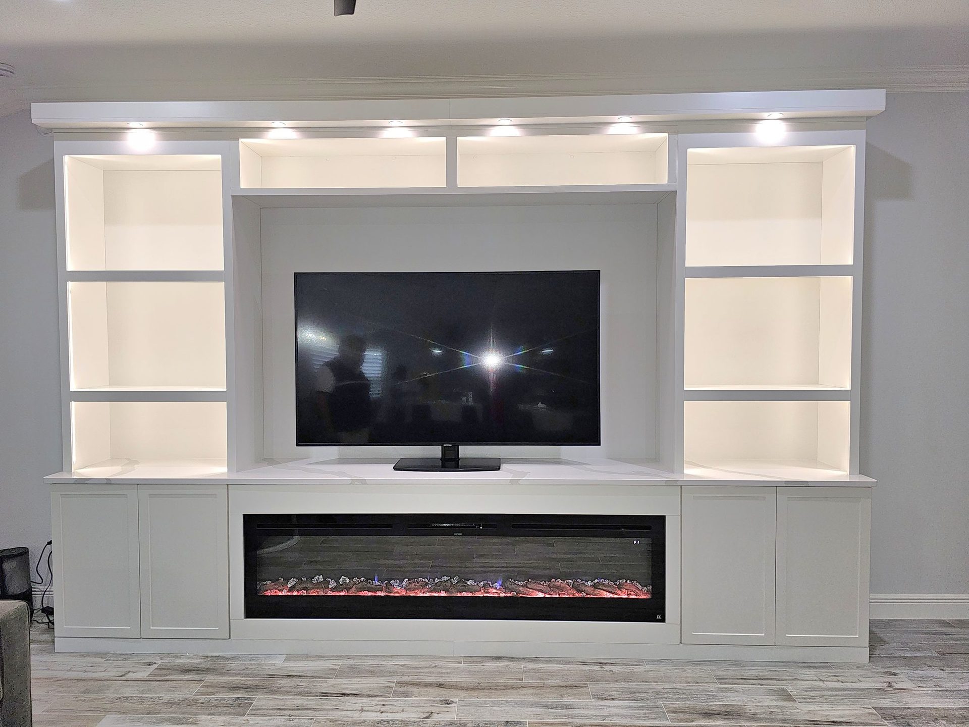 Entertainment wall with shelving and cabinetry by Create More Space