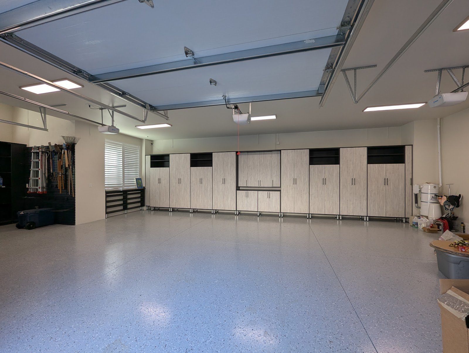 Custom garage with full cabinetry, workbench and epoxy floor