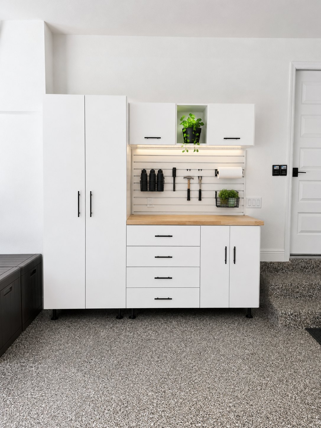 Custom garage cabinets with butcher-block workbench and slat wall by Create More Space
