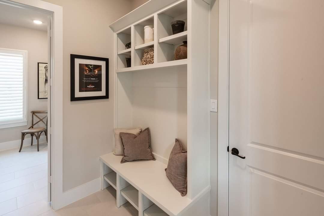 Mudroom with white cubbies and bench seating by Create More Space