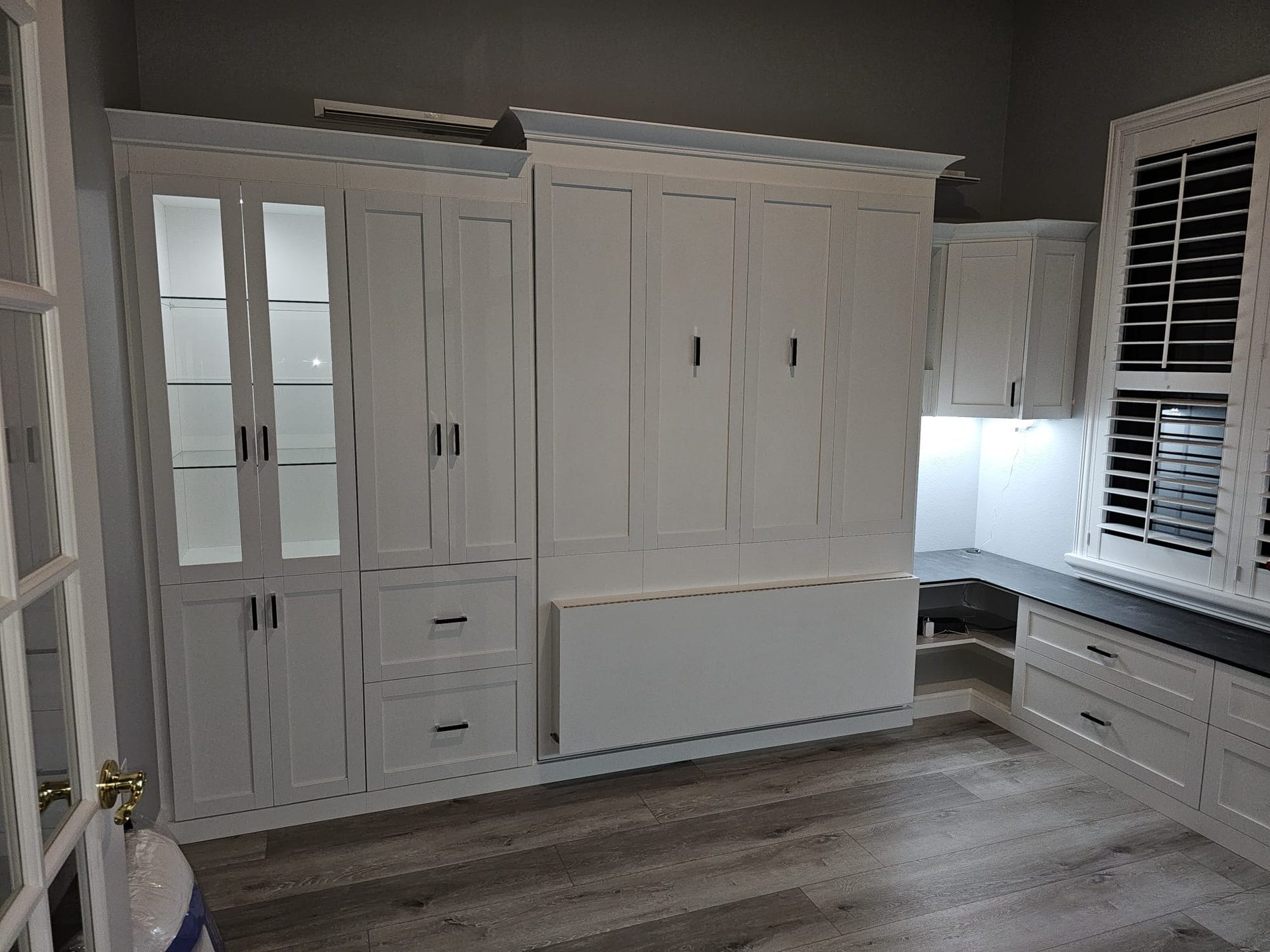 Custom home office with wall bed and shutters by Create More Space