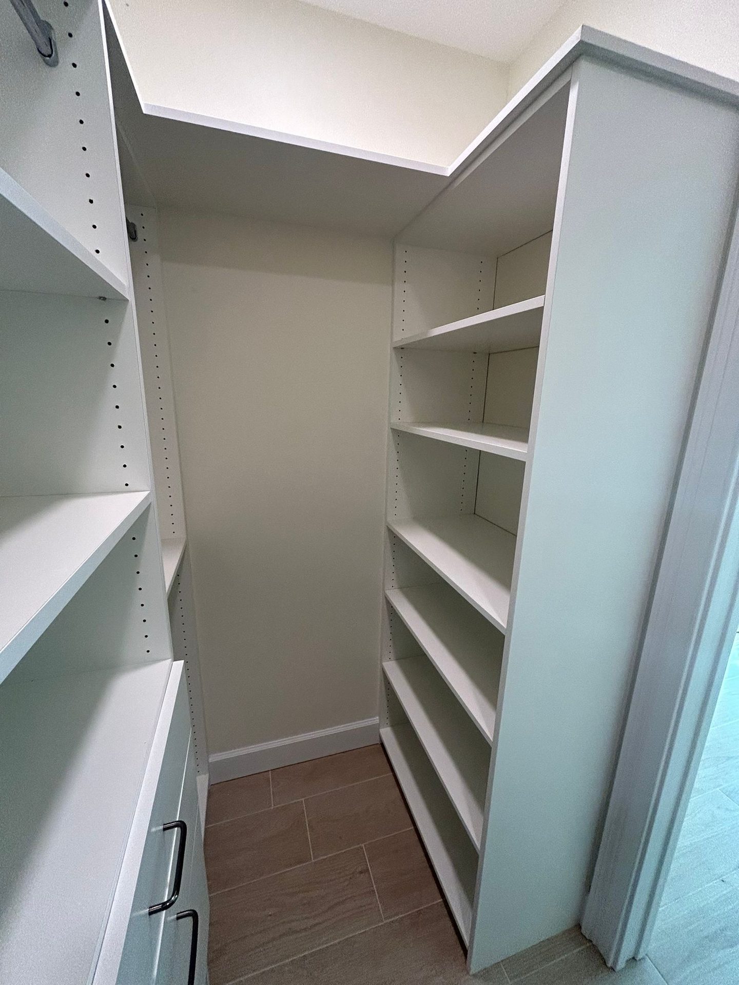 Compact reach-in closet corner with hanging and shelving