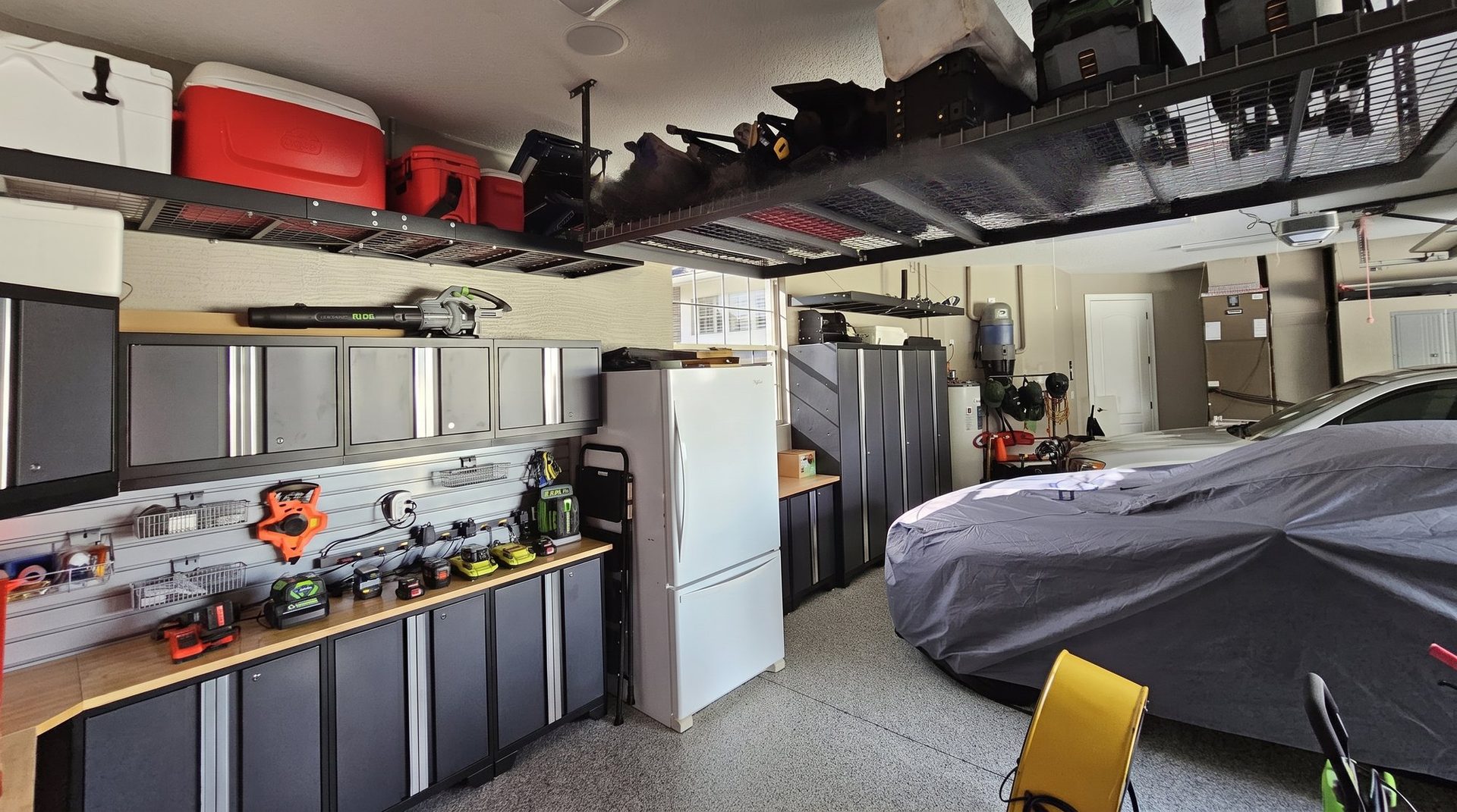 Garage with workbench, cabinets and epoxy floor by Create More Space