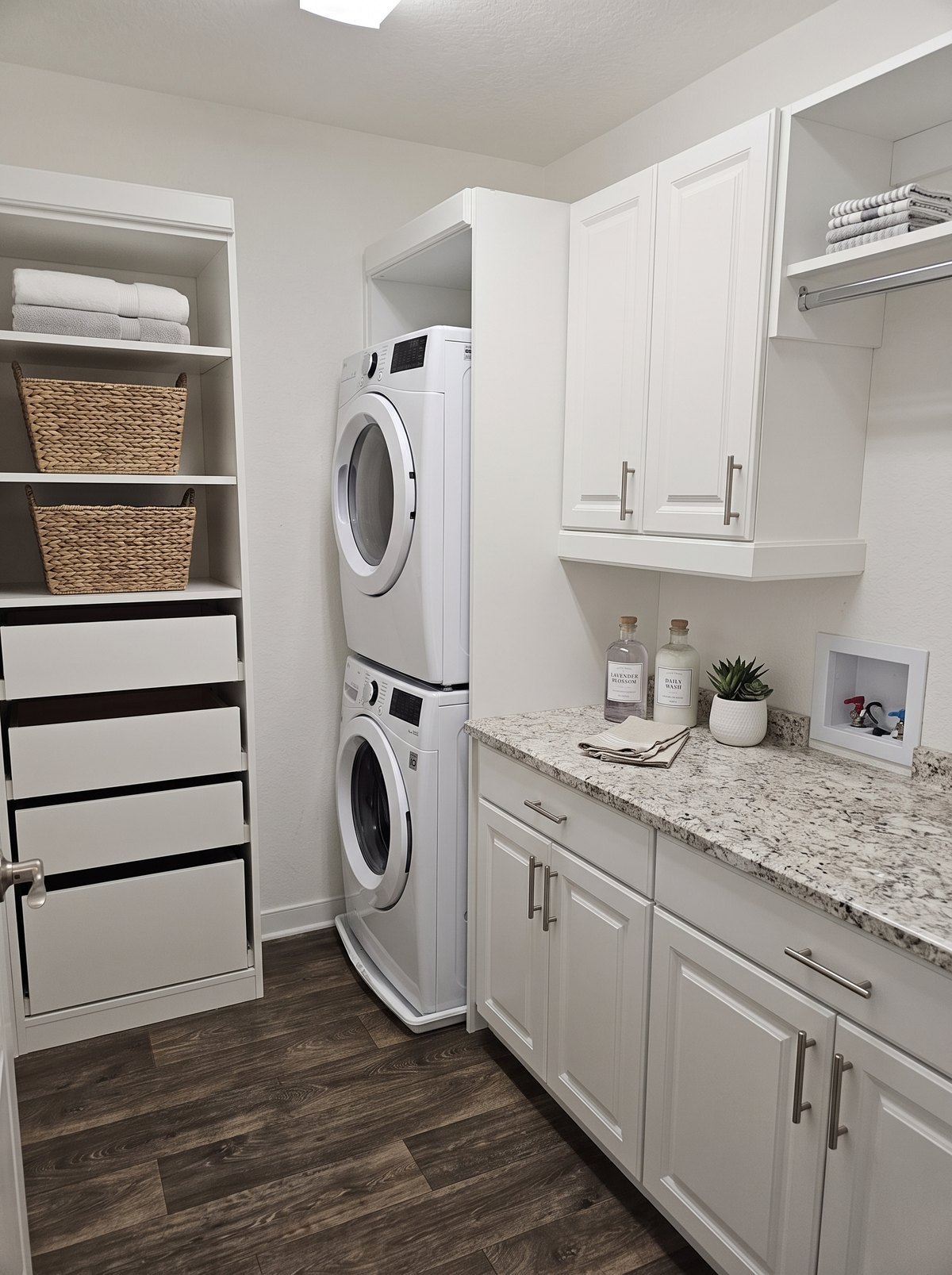 Laundry room with stacked washer and dryer and custom storage by Create More Space