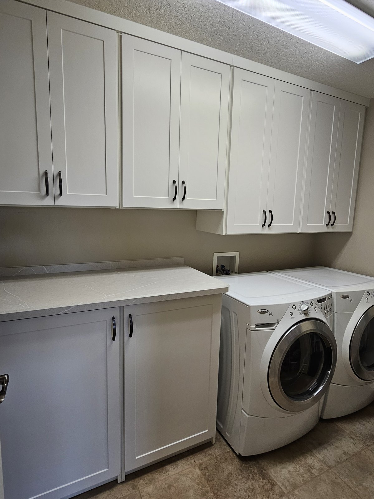 Laundry room with front-load washer and dryer by Create More Space